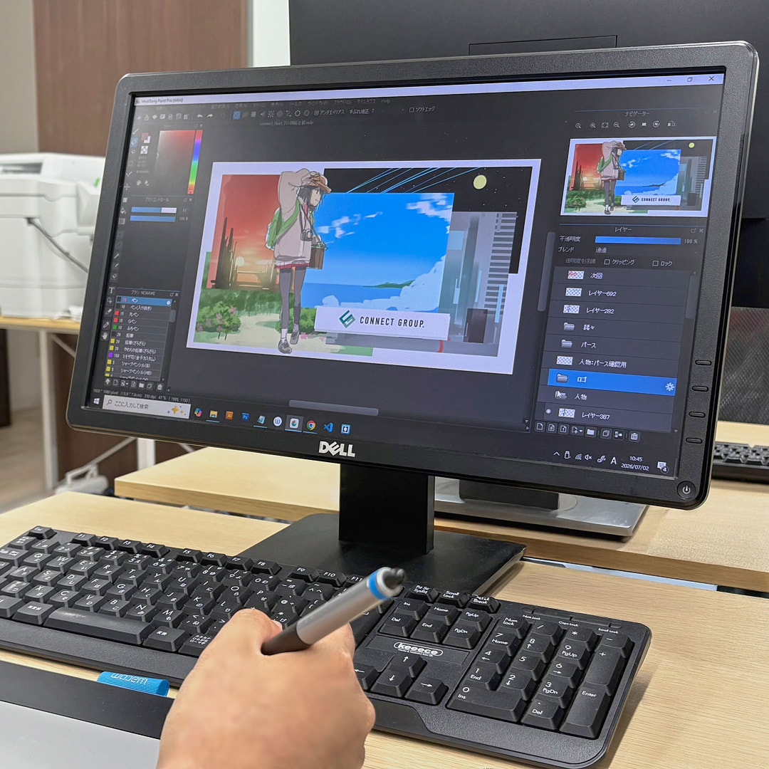 イラスト制作ソフトの画面を見ながらペンタブレットで作業しているところ