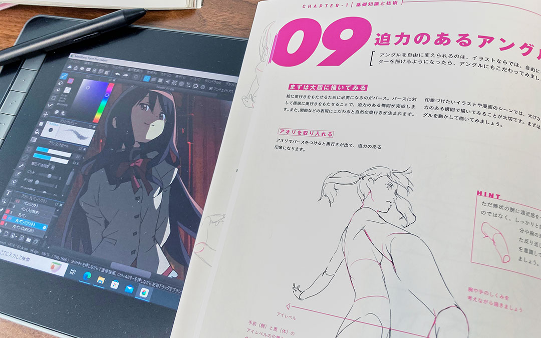 液晶タブレットでイラストを制作している画面と、作画の教本